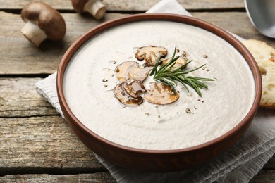 Photo of Fresh homemade mushroom soup served on wooden table, closeup