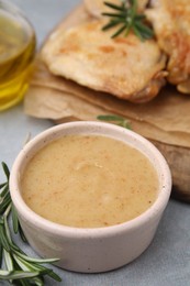 Photo of Delicious turkey gravy and rosemary on grey table