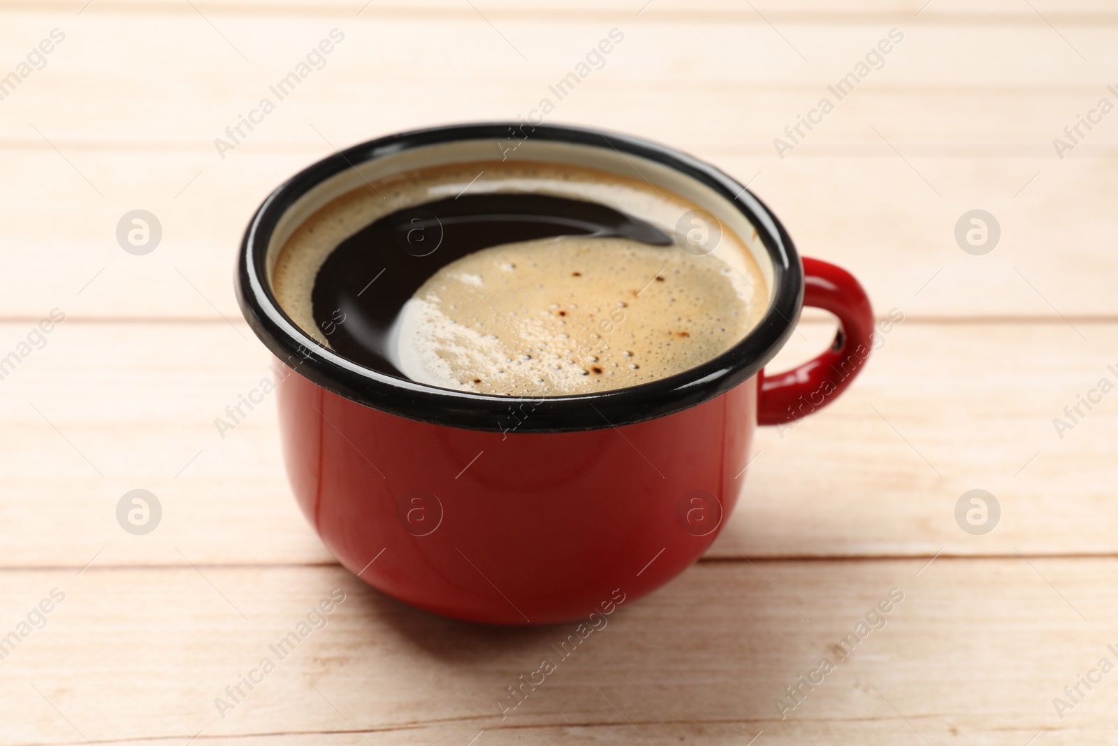 Photo of Cup of aromatic coffee on light wooden table, closeup