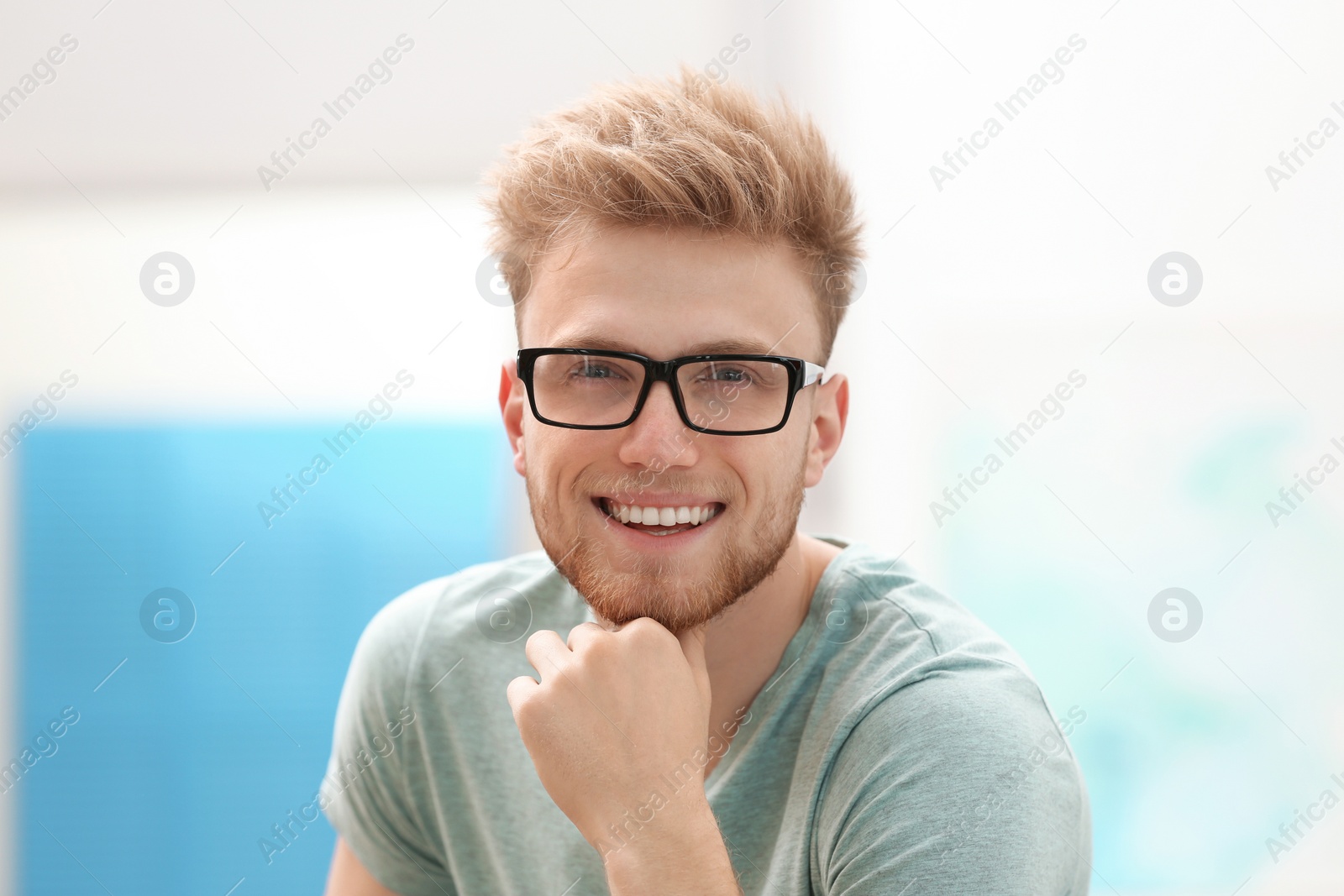 Photo of Portrait of handsome young man with glasses in room