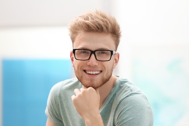 Photo of Portrait of handsome young man with glasses in room