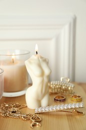 Beautiful female body shape candle on wooden table. Stylish decor