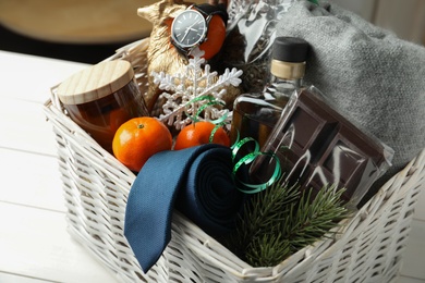 Photo of Wicker basket with Christmas gift set on white table