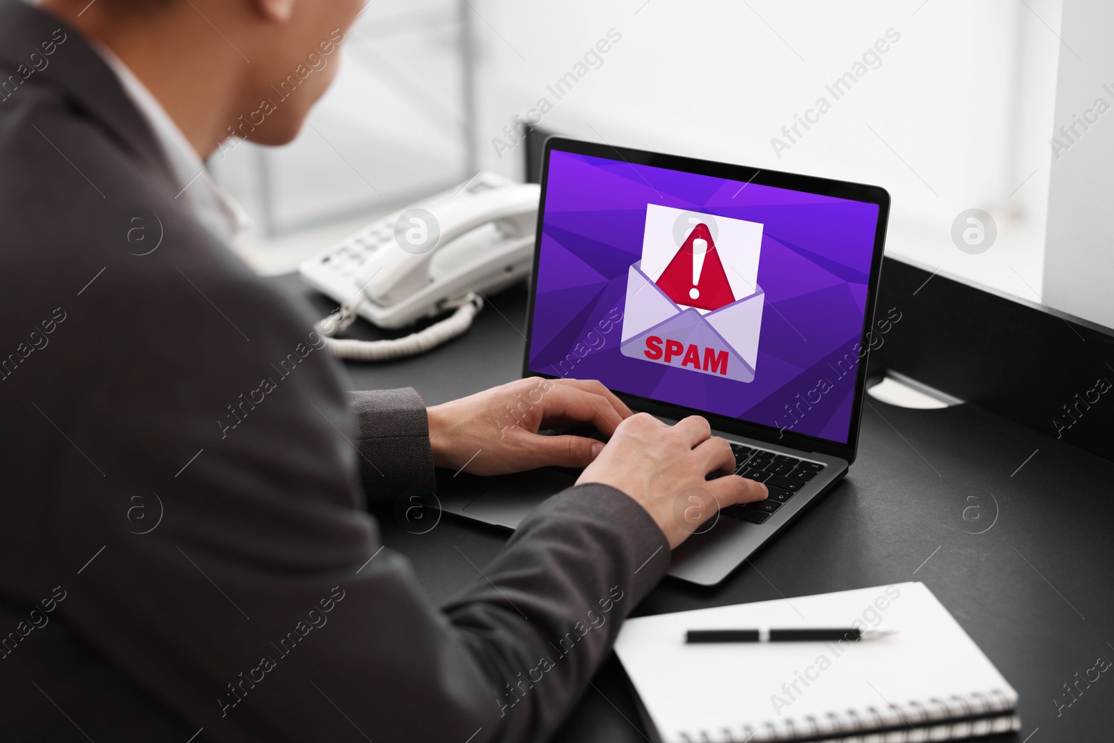 Image of Man using laptop at table, closeup. Spam message notification on device screen, illustration