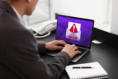 Image of Man using laptop at table, closeup. Spam message notification on device screen, illustration