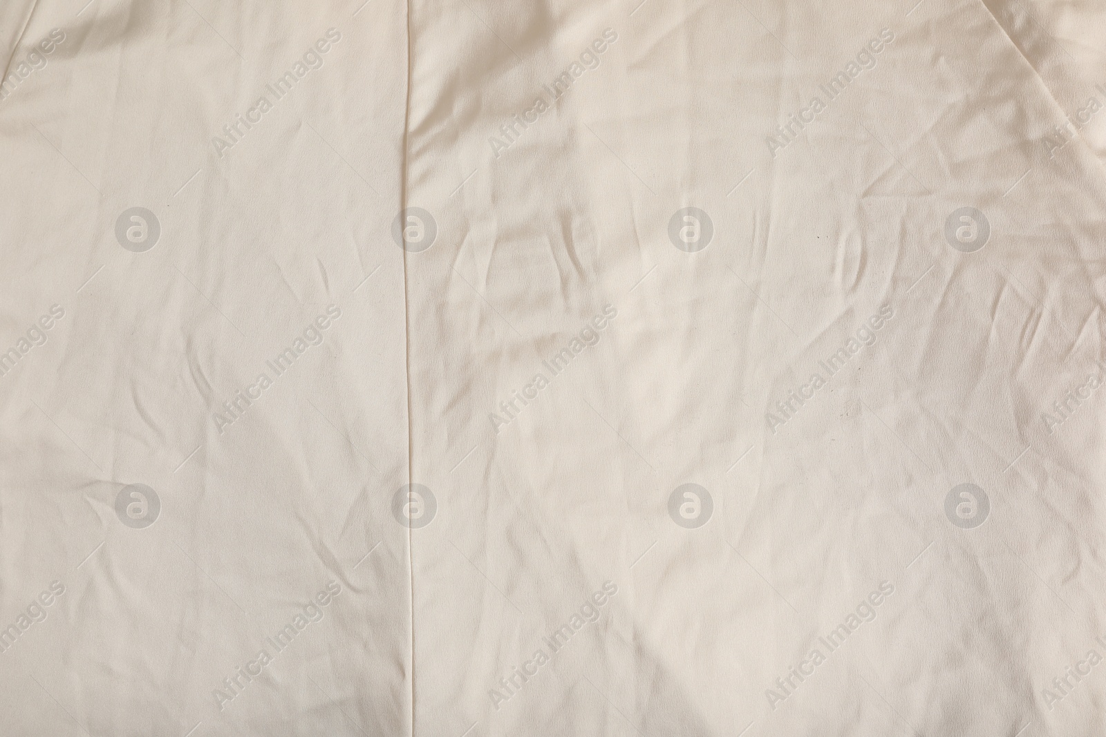 Photo of Crumpled beige fabric as background, closeup view