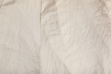 Photo of Crumpled beige fabric as background, closeup view