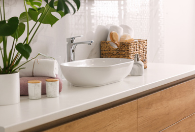 Stylish vessel sink on light countertop in modern bathroom