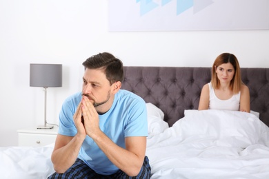 Photo of Couple with relationship problems ignoring each other in bedroom