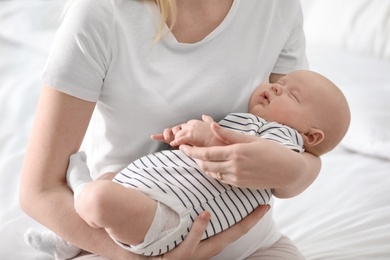 Mother holding her little baby on light background