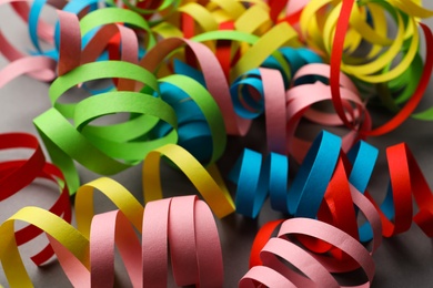 Colorful serpentine streamers on grey background, closeup