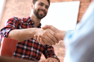 Photo of Business partners shaking hands after meeting, closeup