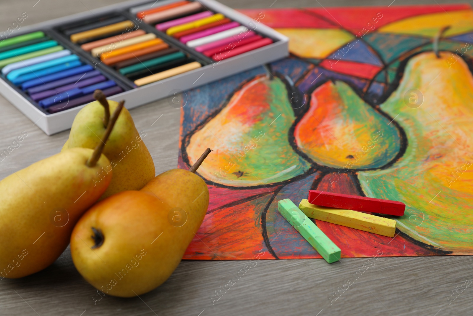 Photo of Beautiful drawing of pears, fresh fruits and colorful pastels on wooden table