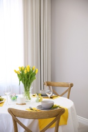 Beautiful Easter table setting with floral decor indoors