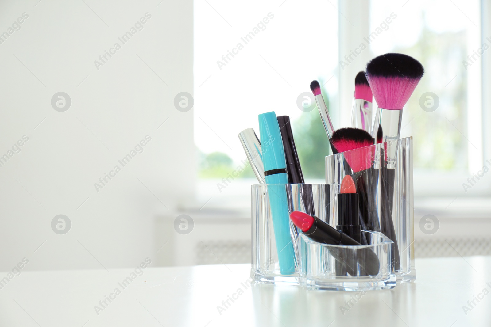 Photo of Organizer with makeup cosmetic products on table indoors. Space for text