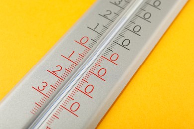 Modern weather thermometer on yellow background, closeup