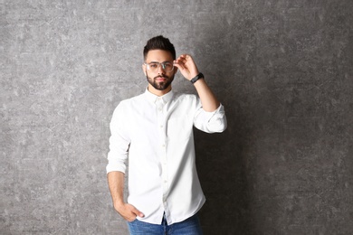 Portrait of handsome man in glasses on grey background