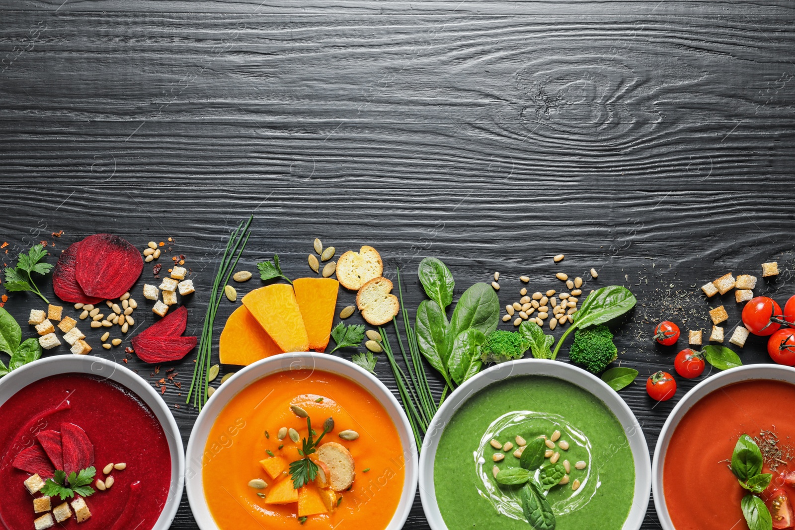 Photo of Flat lay composition with various soups, ingredients and space for text on wooden background. Healthy food