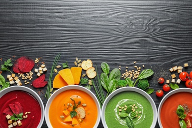 Photo of Flat lay composition with various soups, ingredients and space for text on wooden background. Healthy food