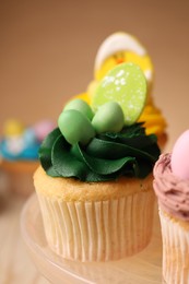 Photo of Tasty cupcake with Easter decor on stand, closeup