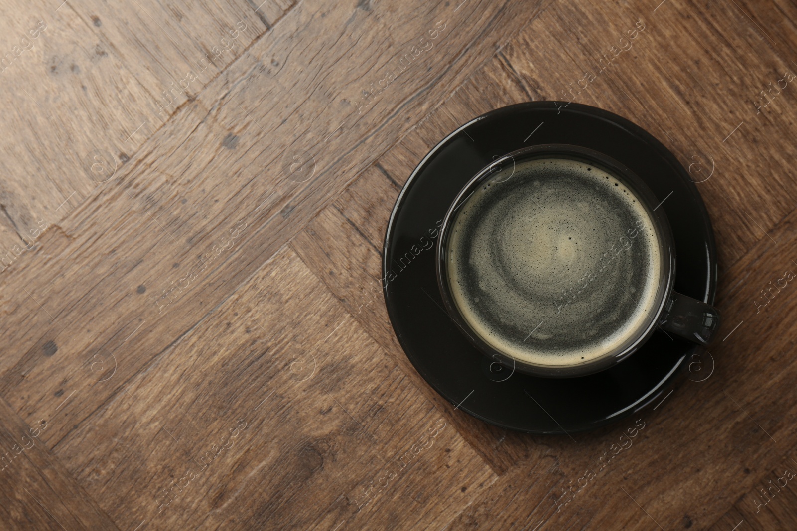 Photo of Hot coffee in cup on wooden table, top view. Space for text