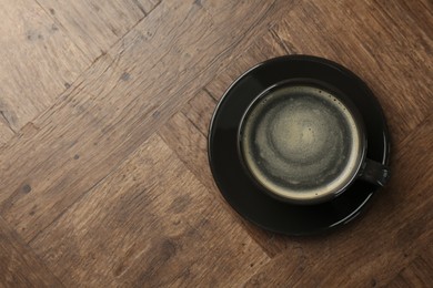 Photo of Hot coffee in cup on wooden table, top view. Space for text