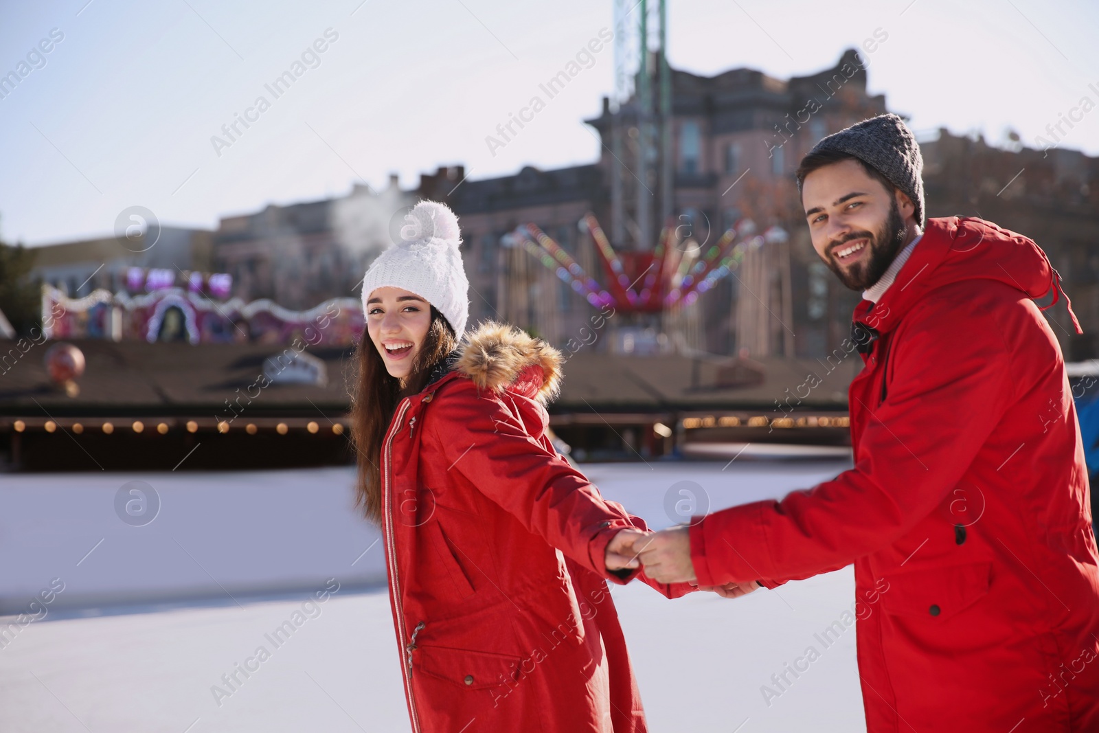 Image of Lovely couple spending time together at outdoor ice skating rink