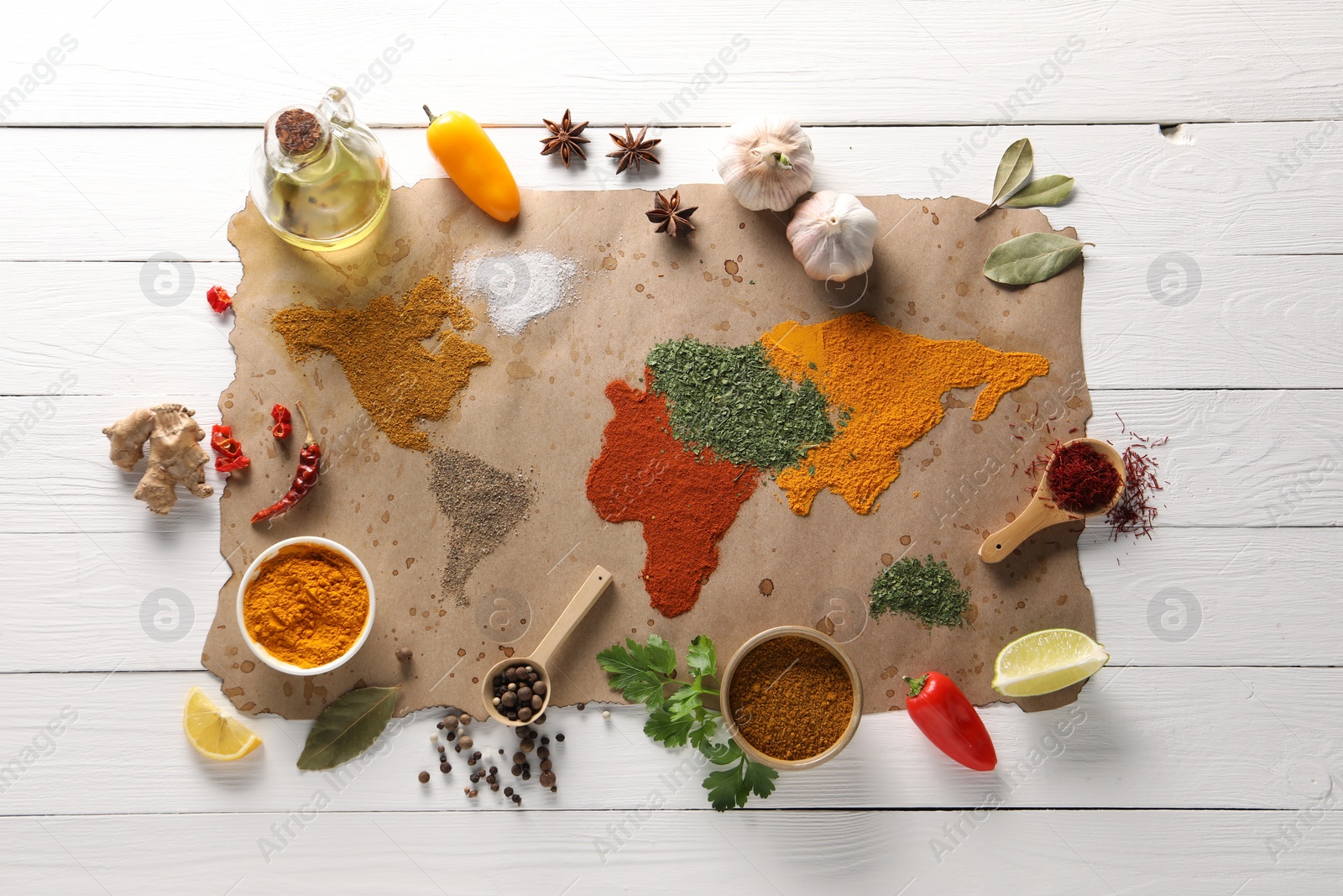 Photo of World map of different spices and products on white wooden table, top view