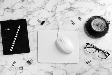 Flat lay composition with mouse and cup of coffee on white marble table