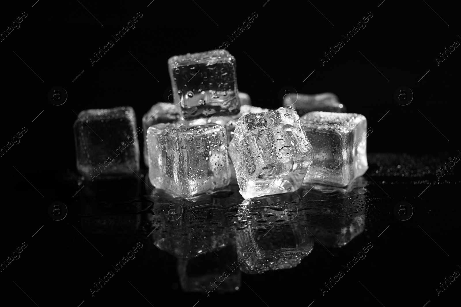 Photo of Pile of crystal clear ice cubes on black background