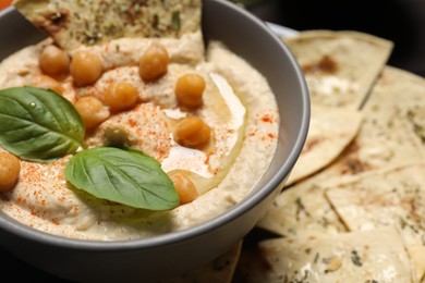 Photo of Delicious creamy hummus with chickpeas and chips on table, closeup