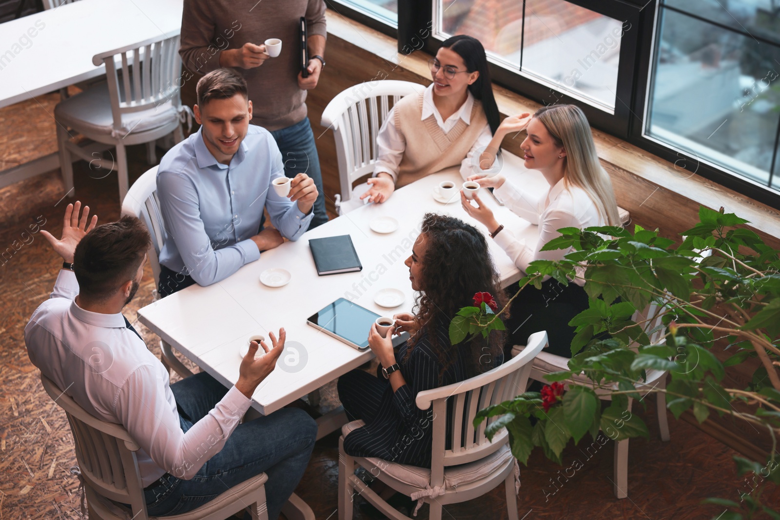 Photo of Group of coworkers having coffee break in cafe