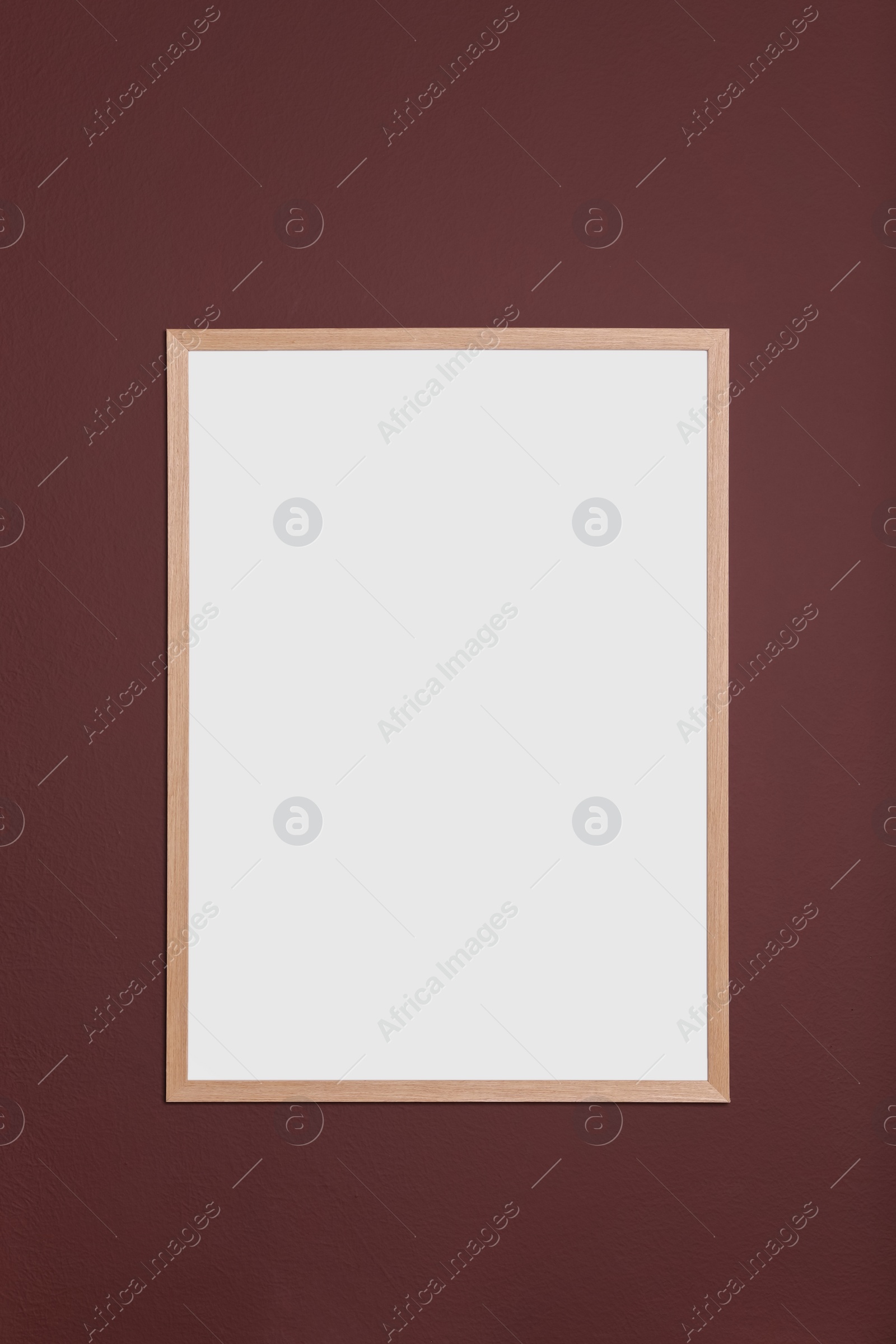 Photo of Blank frame hanging on dark wall. Space for design