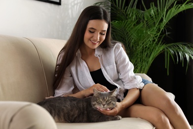 Photo of Young woman with cute cat at home. Pet and owner