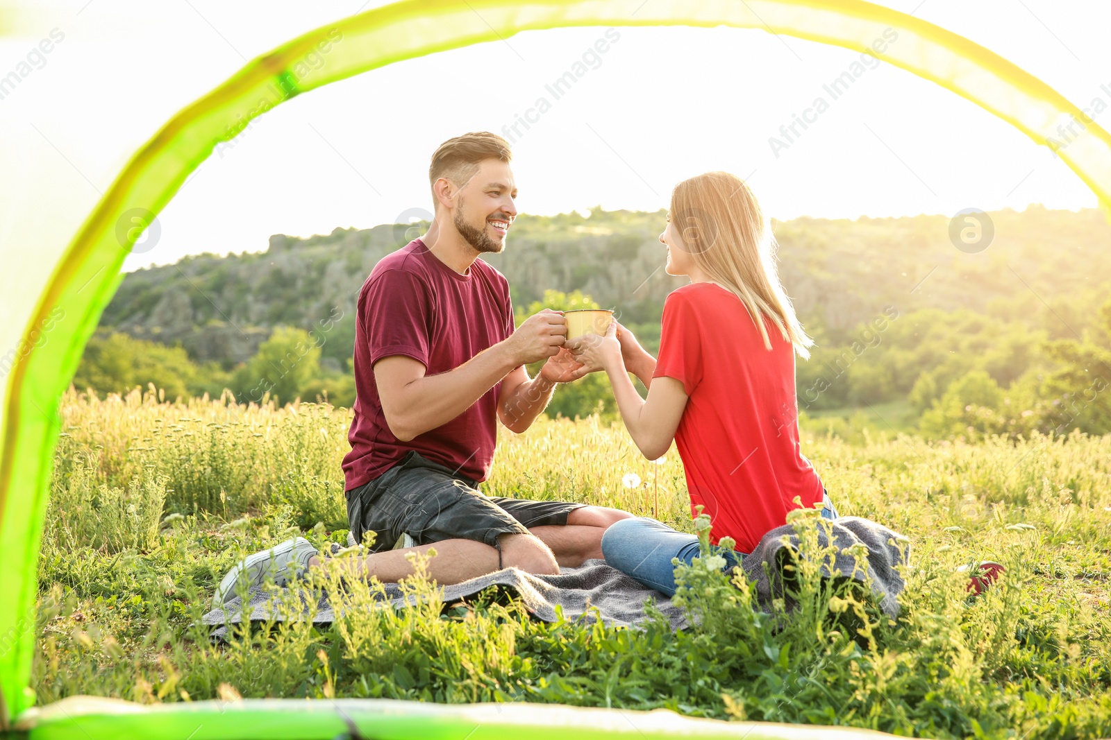 Photo of Lovely couple spending time together in wilderness, view from inside of camping tent