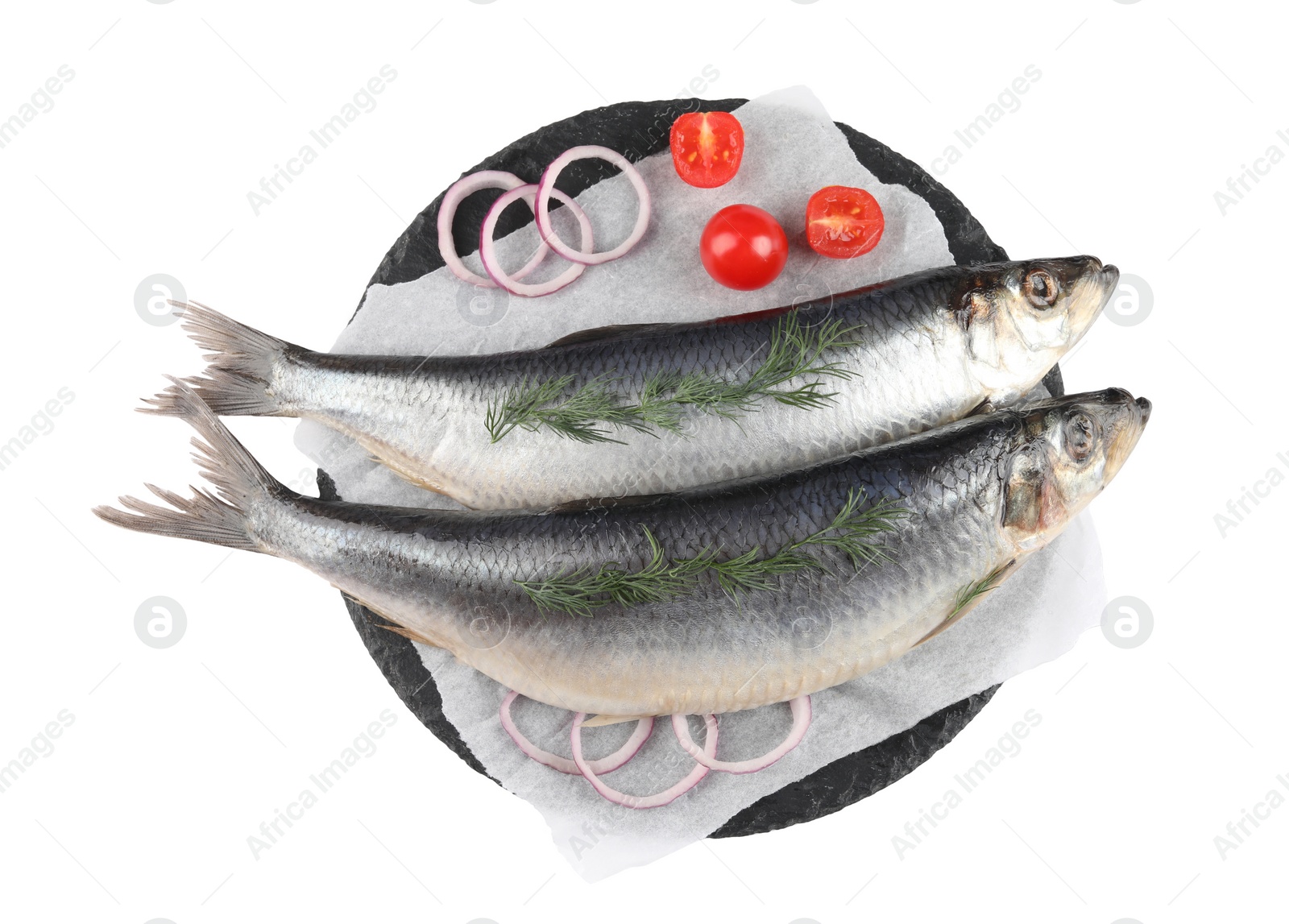 Photo of Slate plate with salted herrings, onion rings, dill and cherry tomatoes isolated on white, top view