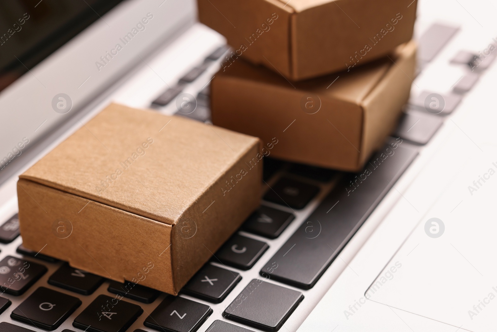 Photo of Mini boxes on laptop, closeup. Online store