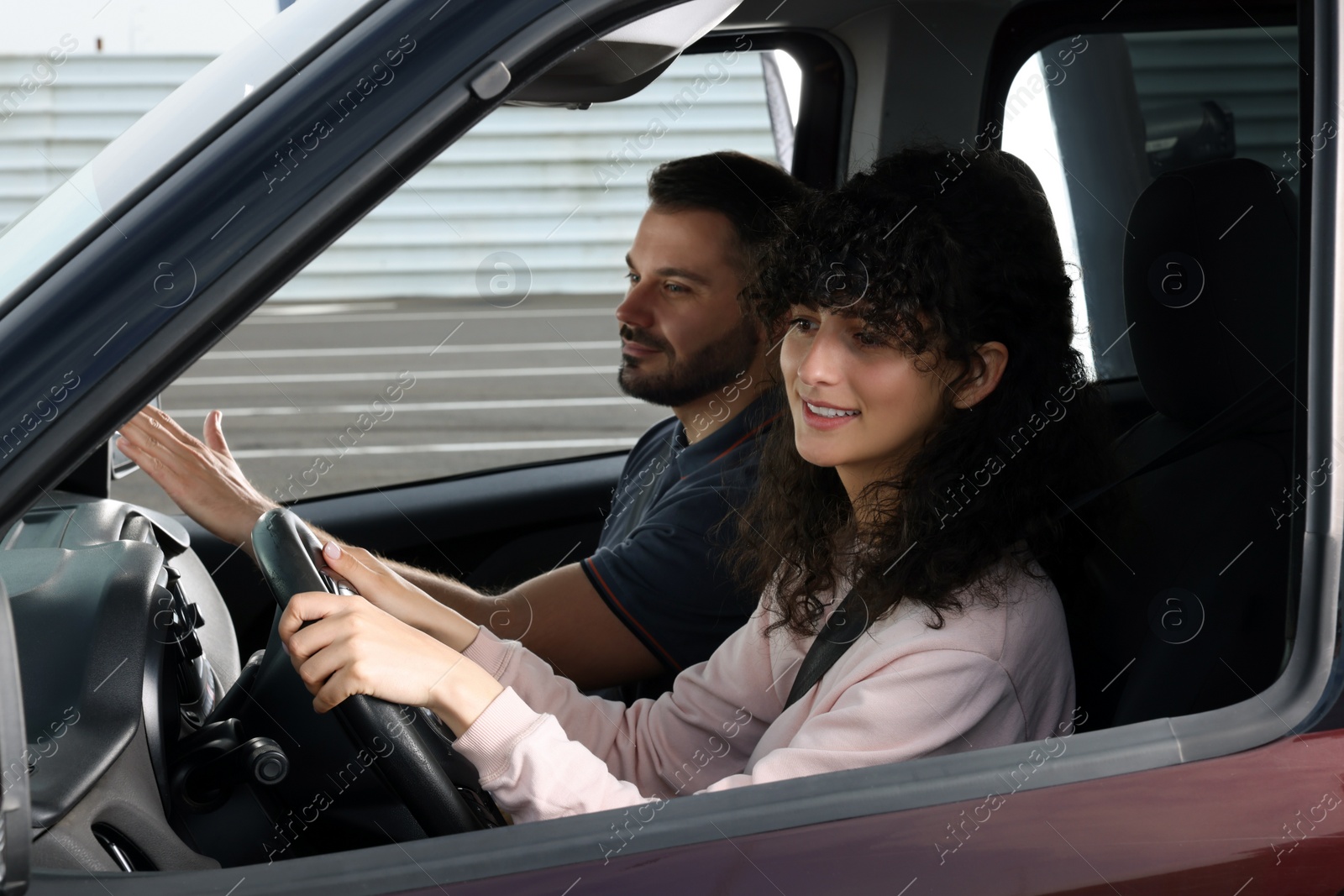 Photo of Driving school. Student during lesson with driving instructor in car