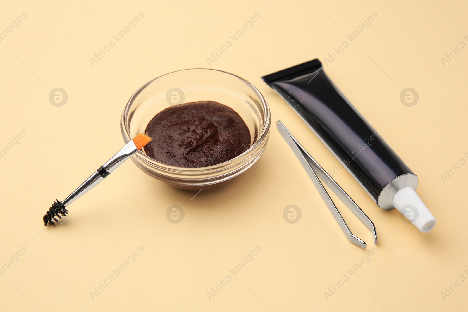 Photo of Eyebrow henna and tools on beige background