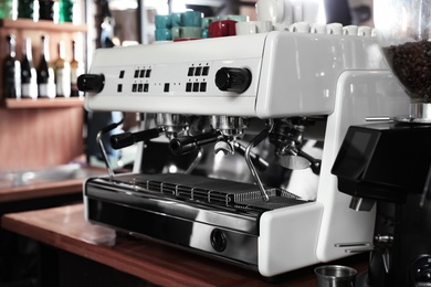 Photo of Modern coffee machine on bar counter in cafe
