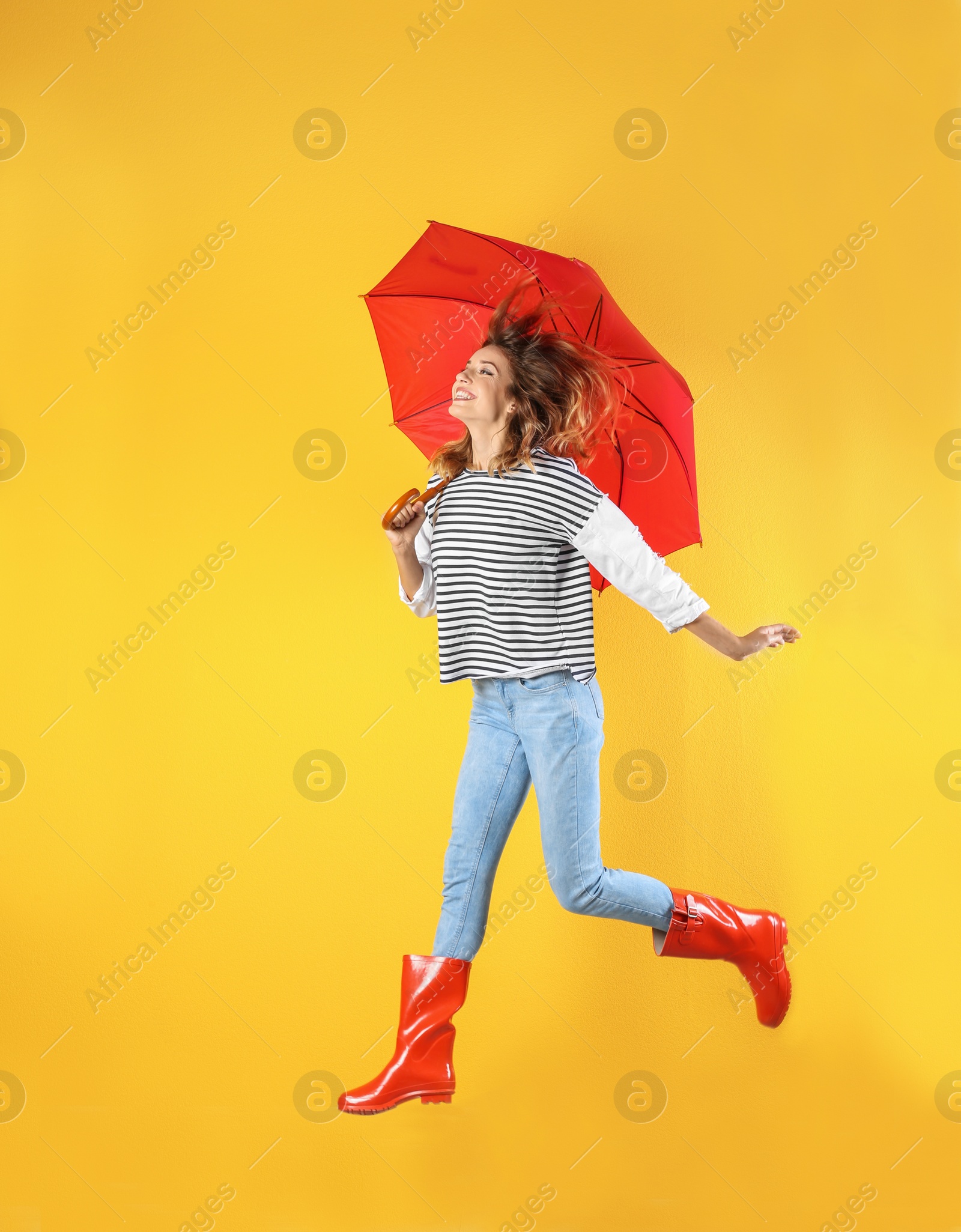 Photo of Woman with red umbrella near color wall