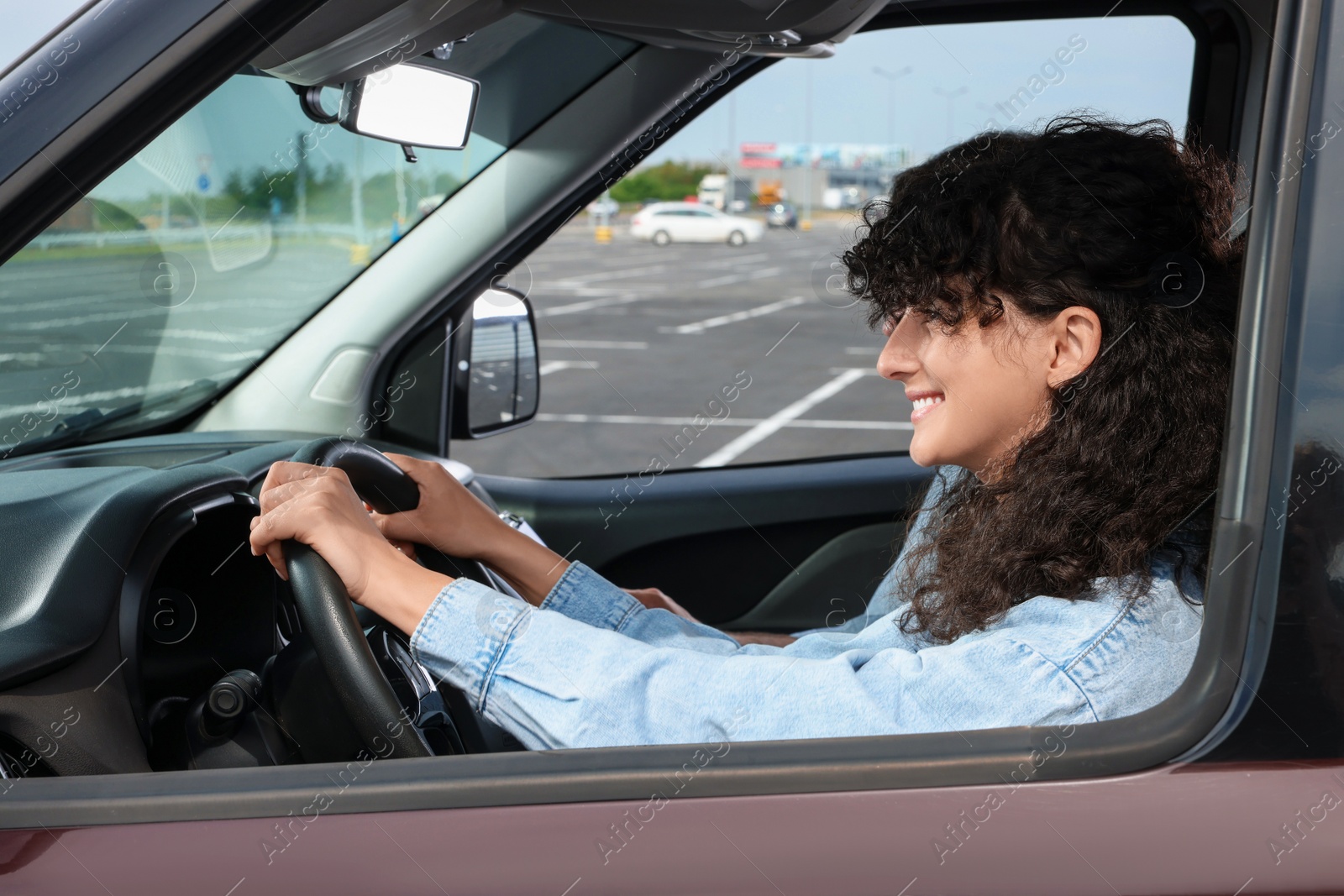 Photo of Driving school. Happy student during lesson with driving instructor in car at parking lot