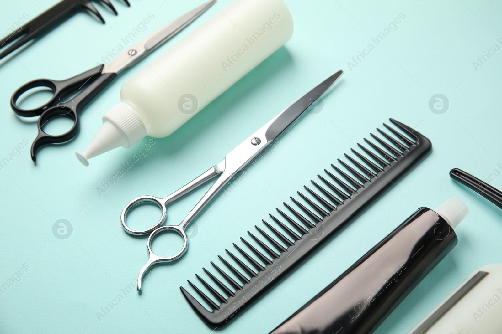 Photo of Professional tools for hair dyeing on light blue background