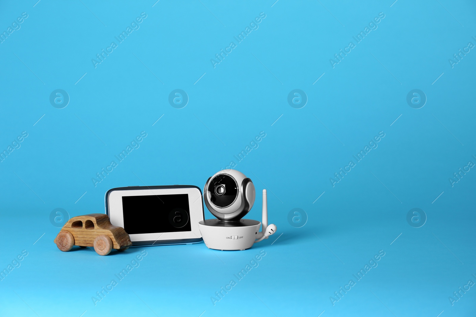 Photo of Modern CCTV security camera, toy car and monitor on color background. Space for text