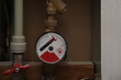 Photo of Water meter and ceramic tile on wall, closeup