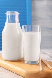 Glassware with tasty milk and straws on table