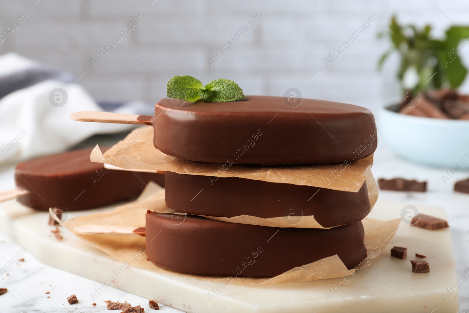 Photo of Delicious glazed ice cream bars with mint on board, closeup