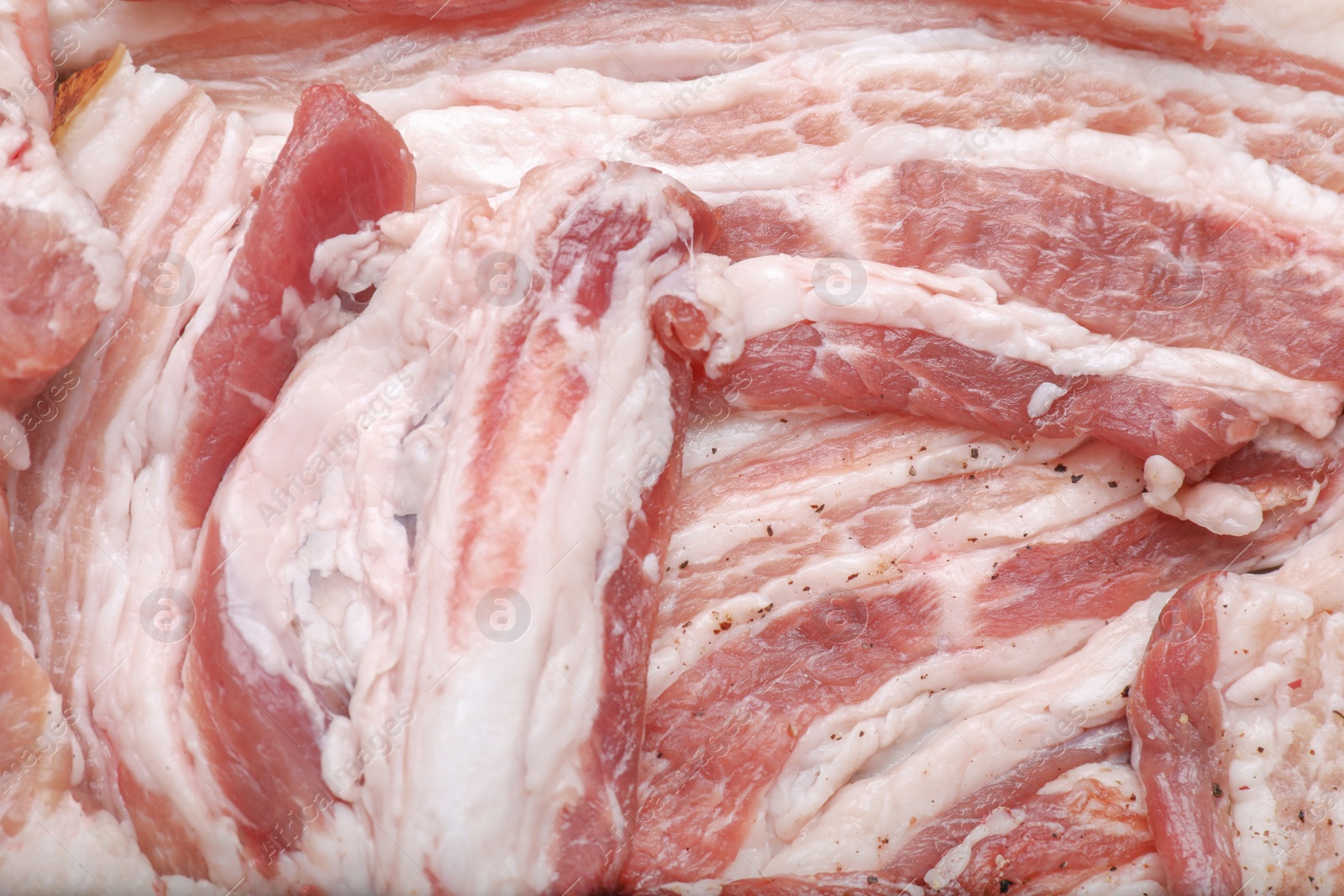 Photo of Tasty pork fatback with spices as background, closeup