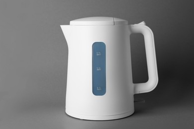 New modern electric kettle on grey background