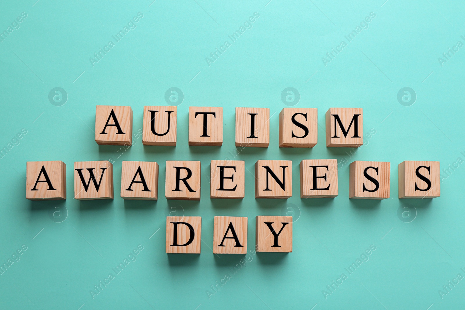 Photo of Cubes with phrase "Autism awareness day" on color background